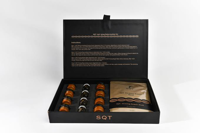 Open black box containing SQT anti-aging serum vials and repair masks with instructions inside lid