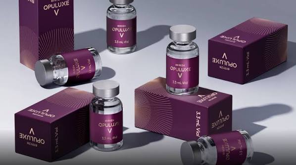 Several small glass vials and purple boxes labeled Opuluxe V arranged on a surface